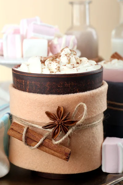 Mug of hot drink decorated in felt on wooden table