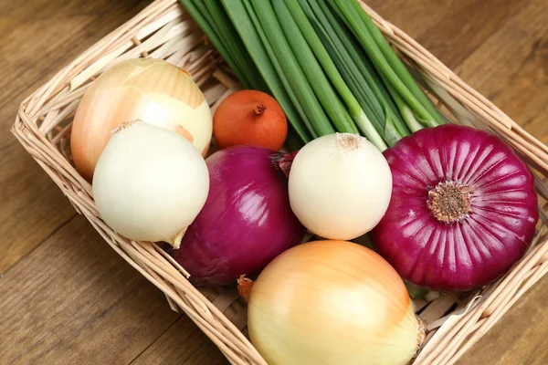 Different raw onion on wooden background