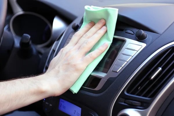 Hand with microfiber cloth polishing car