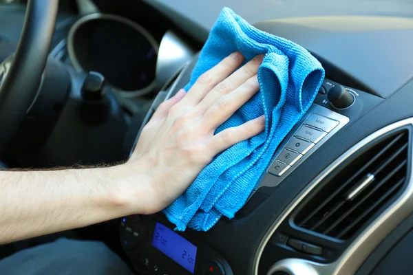 Hand with microfiber cloth polishing car