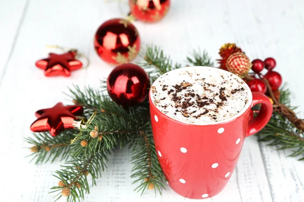 Hot chocolate with cream in color mug, on table, on Christmas decorations background