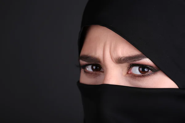 Beautiful muslim arabic woman in paranja on dark background
