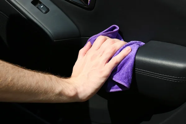 Hand with microfiber cloth polishing car