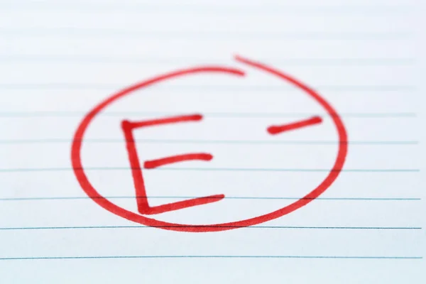 Grade E- written on an exam paper