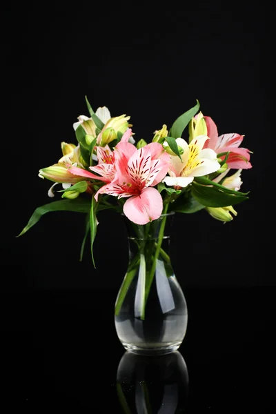 Alstroemeria flowers in vase on table on dark grey background
