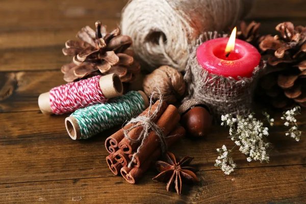 Composition with natural bump, candle, thread, cinnamon sticks