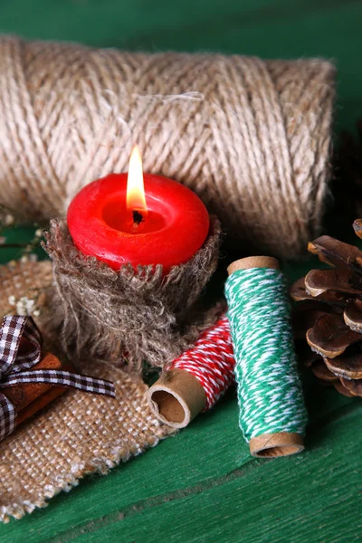 Composition with natural bump, candle, thread, cinnamon sticks on wooden background