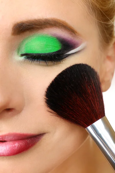 Beautiful woman with bright make-up and brush, close up