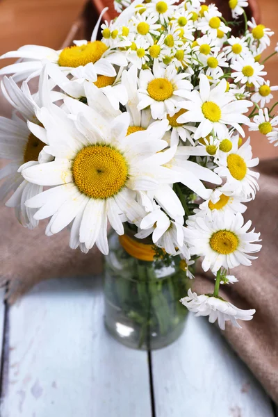 Beautiful bouquet of daisies on wooden background