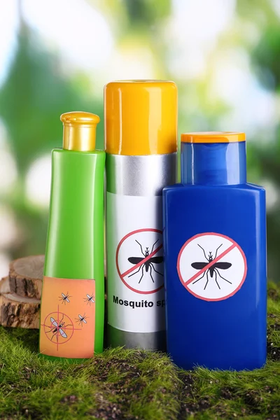Bottles with mosquito repellent cream on nature background