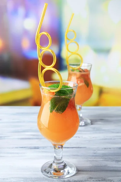 Grapefruit cocktail with cocktail straw on bright background