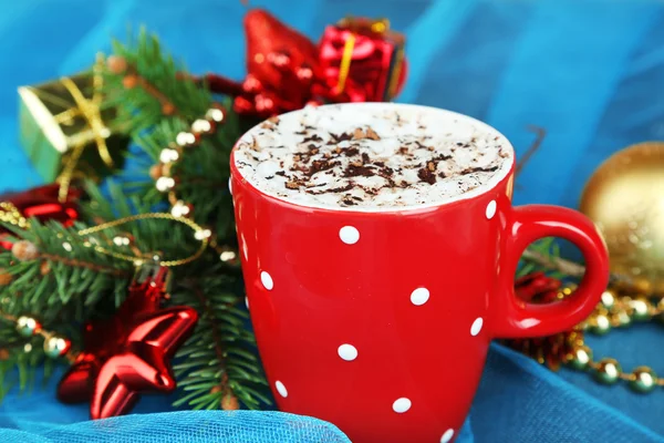 Hot chocolate with cream in color mug, on table, on Christmas decorations background