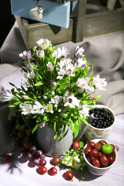 Still life with flowers and fruits on dark background