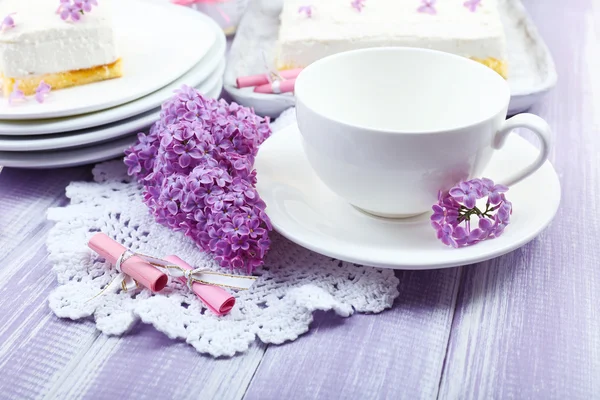 Cup with dessert and lilac flowers