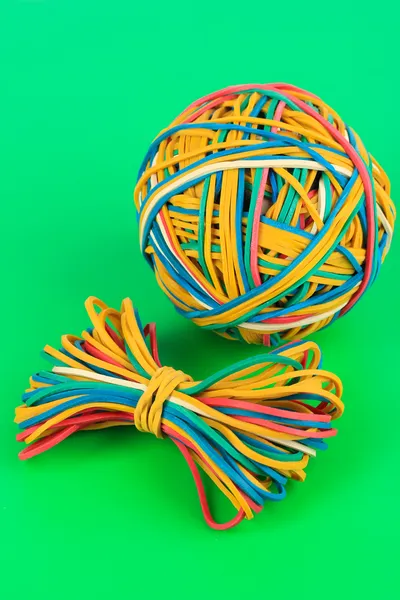 Colorful rubber bands on green background