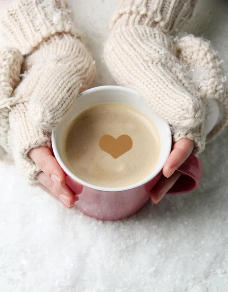 Female hands with hot drink, on light background