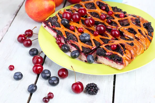 Sweet berries and berry tart on table close-up