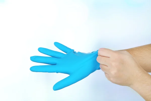 Doctor putting on protective gloves