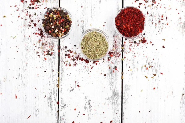 Spices in glass round bowls on wooden background