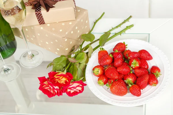 Romantic still life with champagne, strawberry and roses in room