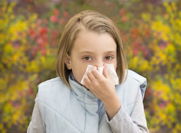 Little girl blowing her nose