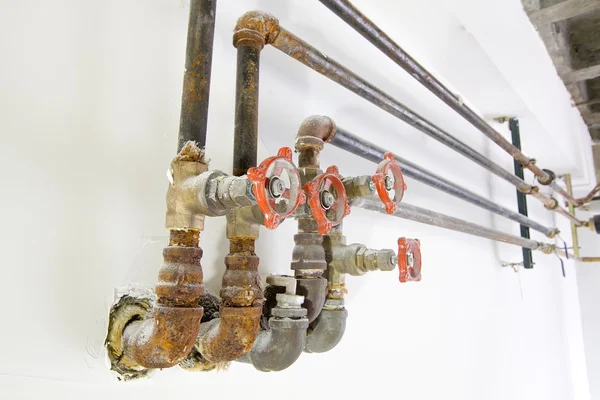 Old Plumbing Pipes with Valves on Wall