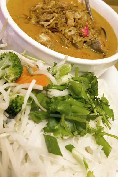 Thai Beef Curry Noodles with Raw Vegetables Closeup