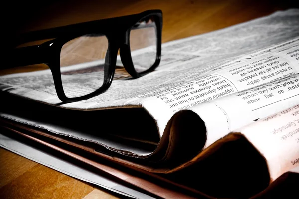 Glasses on stack of newspapers