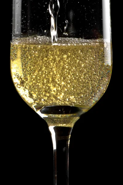 Begin filling a flute of champagne with golden bubbles