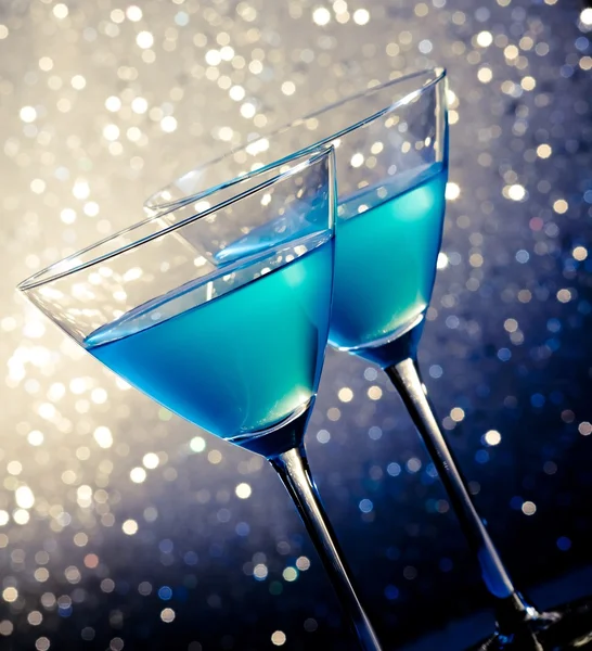 Two glasses of blue cocktail on table