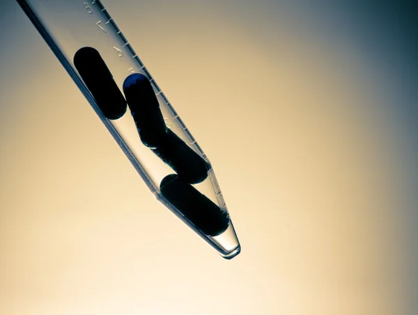 Silhouette of blue pills in test tube, health care concept