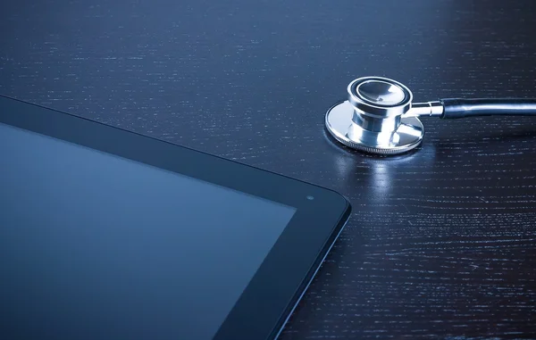 Stethoscope on modern digital tablet pc on wood table