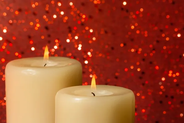 Candles with flame on red bokeh