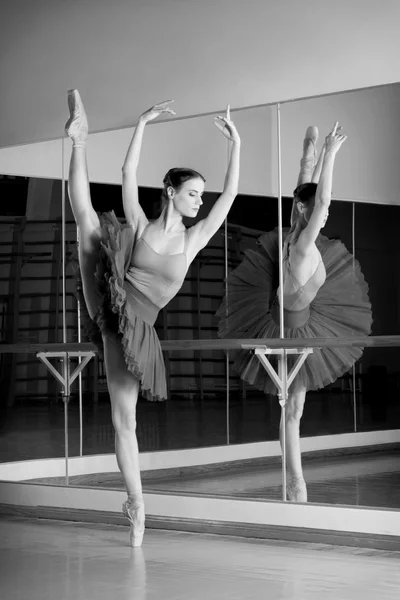 Black and white shoot of beautiful dancer ballerina is doing exercises in ballet class