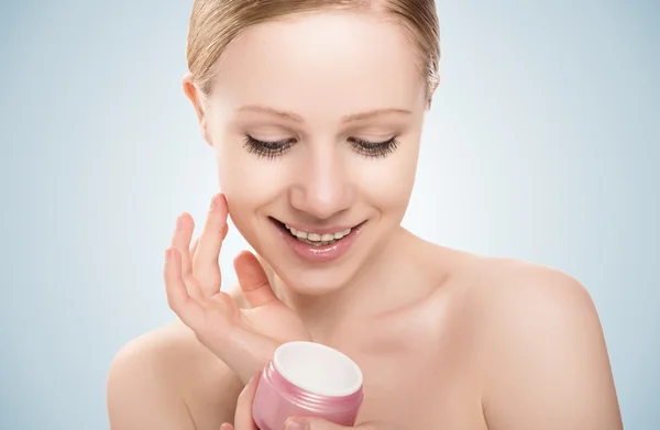 Skin care. beauty girl with eyes closed with jar of cream