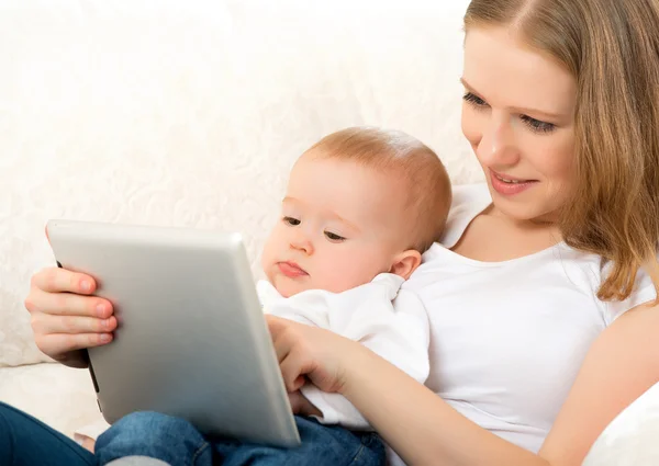 Mother and baby with tablet computer on the couch at home