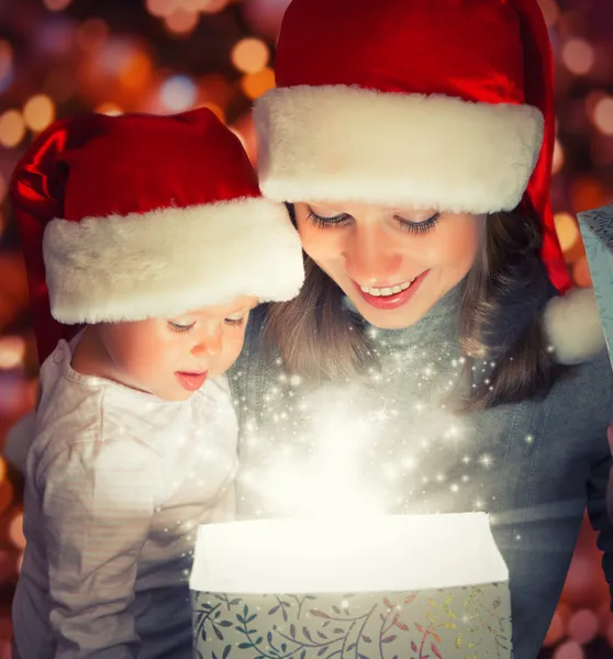 Christmas magic gift box and a happy family mother and baby