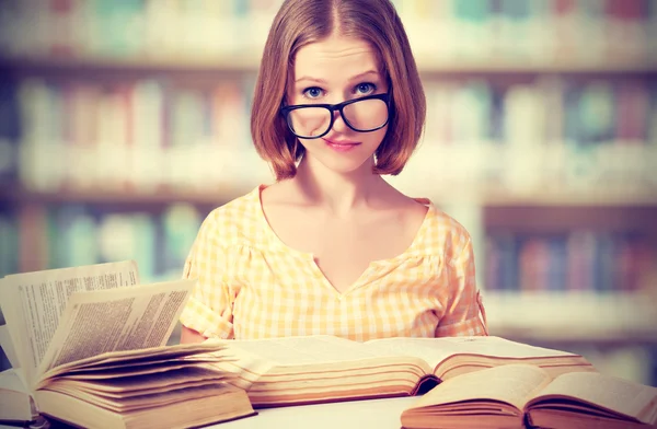 Funny girl student with glasses reading books
