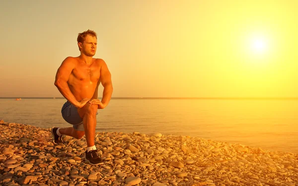 Athlete practicing, playing sports and yoga on the beach at suns