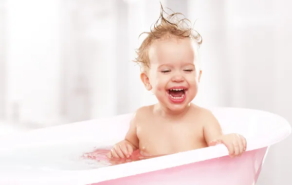 Happy funny baby laughing and bathed in bath