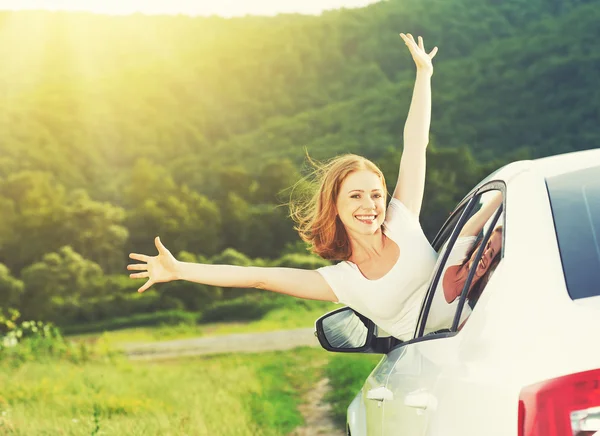 Happy woman looks out the car window on nature