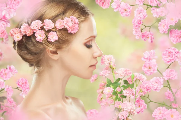 Young beautiful woman with pink flowers in her hair