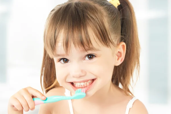 Happy little girl brushing her teeth