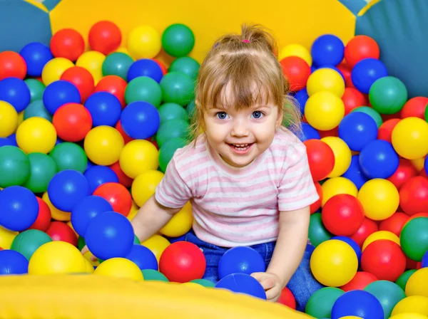 Little girl playing in the pool balls