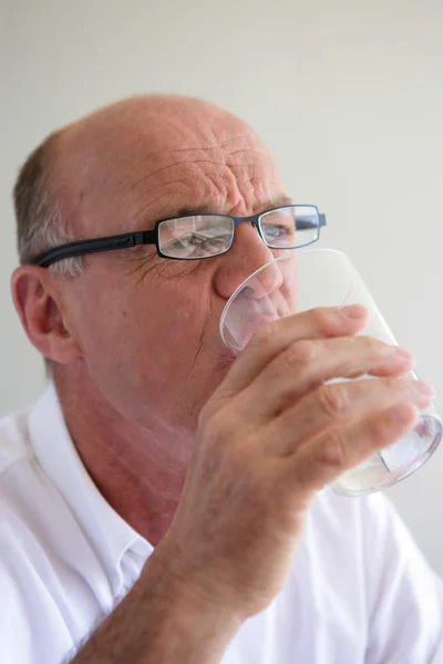 Elderly man drinking a glass of water