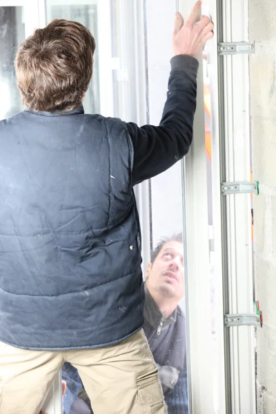 Two men fitting a new window