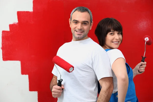 Couple painting wall in red