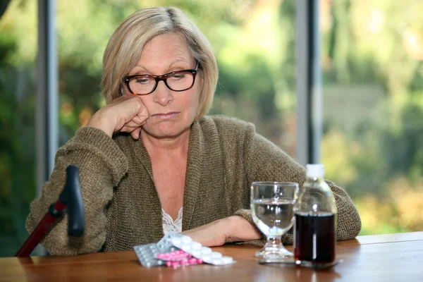 Unhappy woman staring down at her pills
