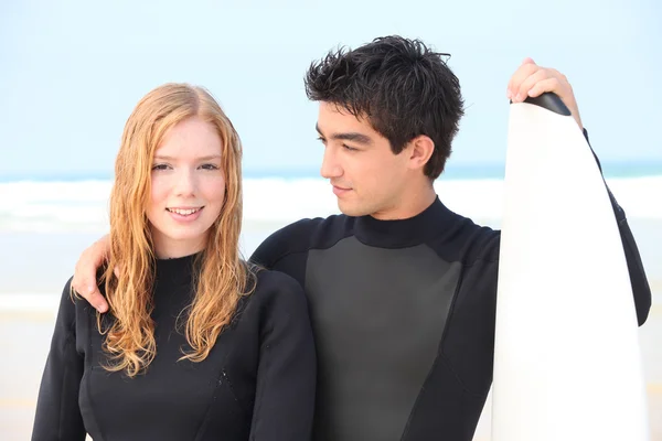 Surfer couple wearing wet-suits — Stock Photo #14706887