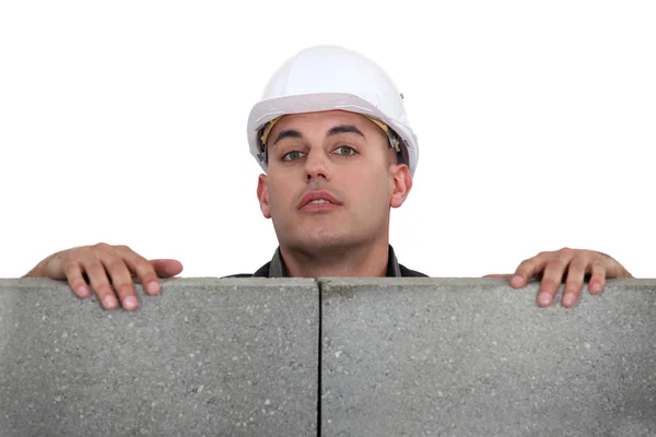 Builder looking over a block wall